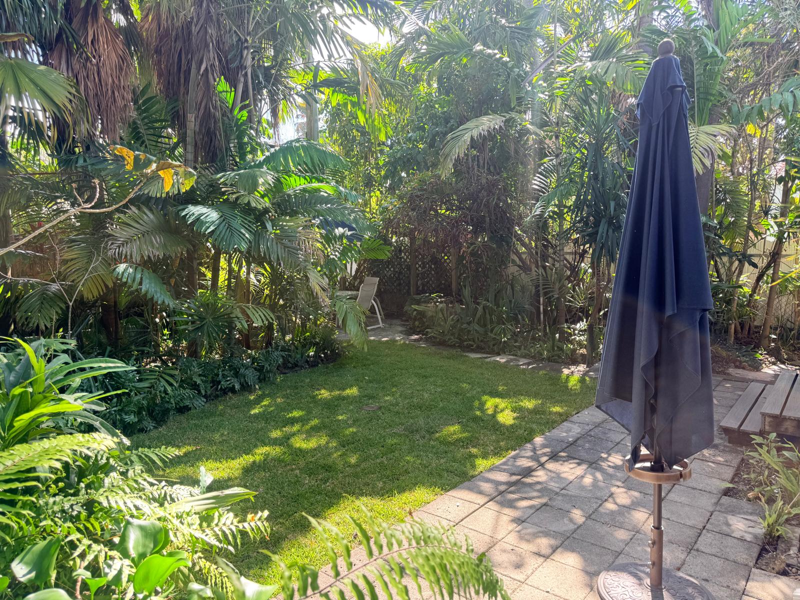 Backyard view showing mature landscaping and garden depth